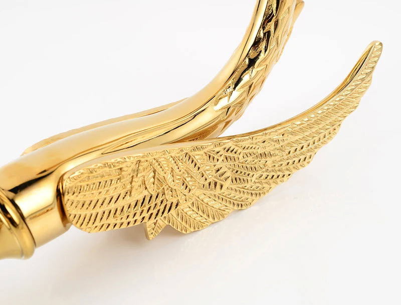 Gold bracelet with winged design on a white background