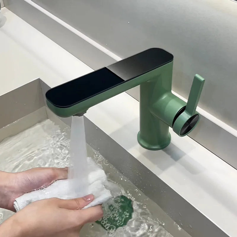 Green faucet with water flowing into a sink