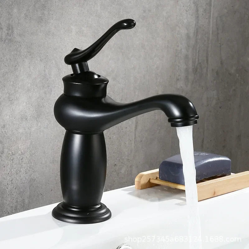 Black faucet with water flowing onto a white surface with a gray background