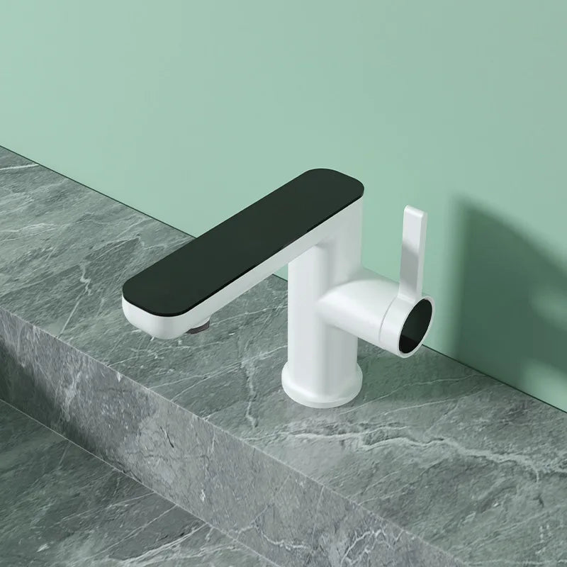 Modern bathroom faucet on a marble countertop with a green wall background
