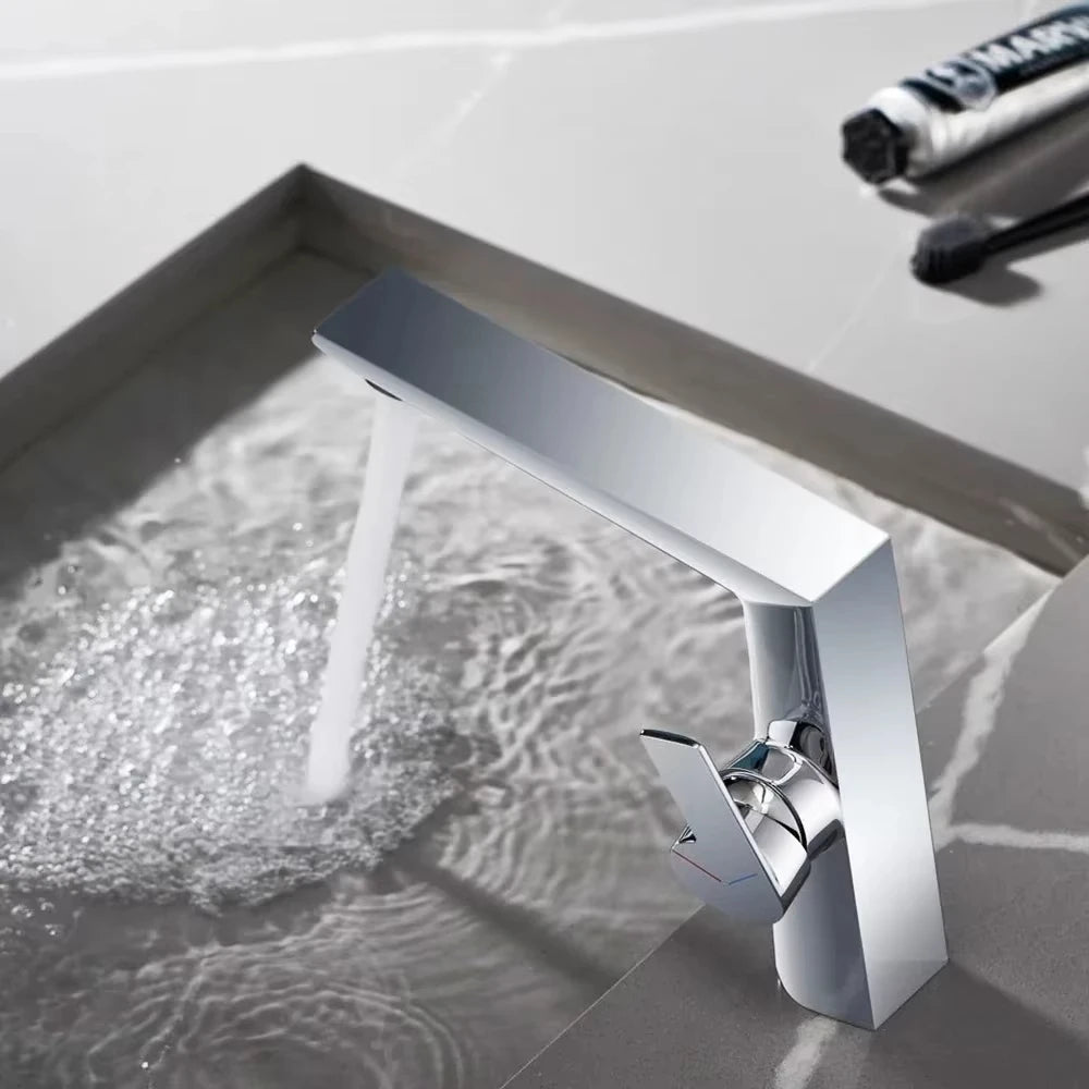 Modern silver faucet with water flowing into a sink