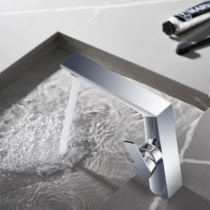 Modern silver faucet with water flowing into a sink